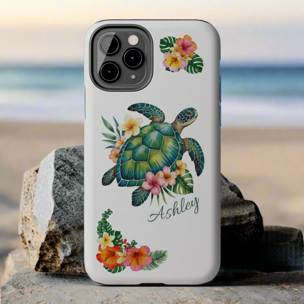 iPhone 13 case with a white background and a sea turtle with hibiscus flowers, with more hibiscus flowers around the sides.