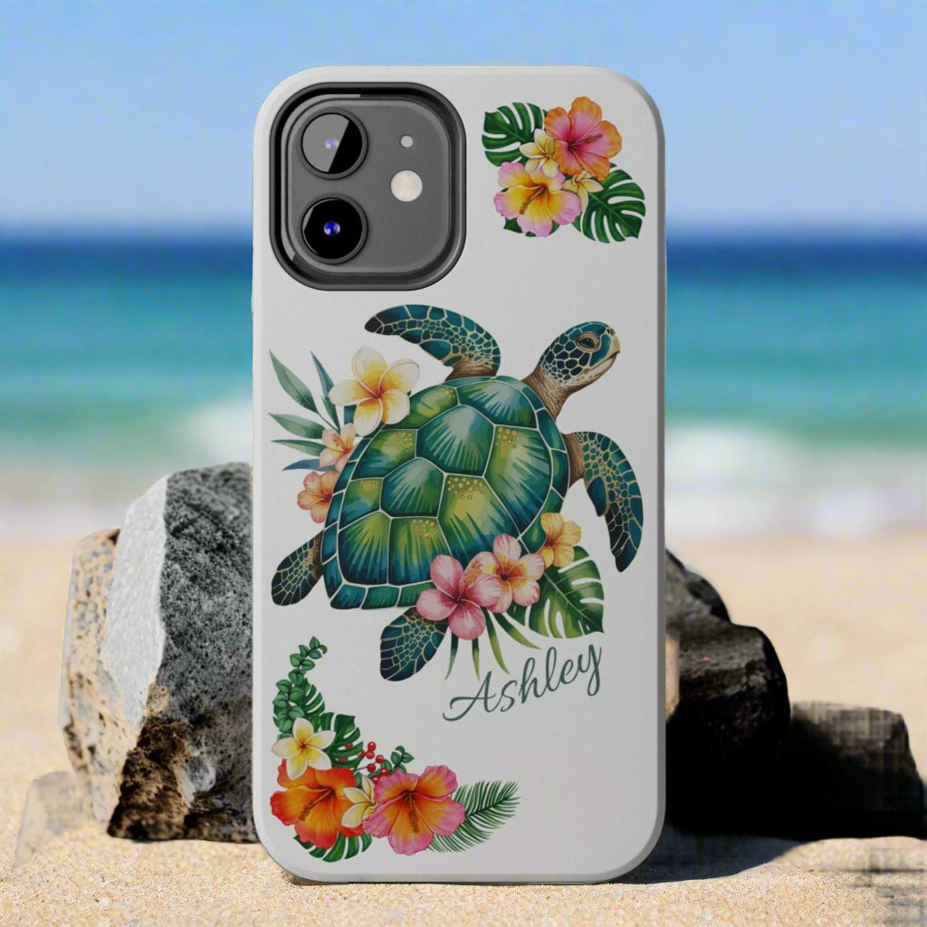iPhone 12 case with a white background and a sea turtle with hibiscus flowers, with more hibiscus flowers around the sides.