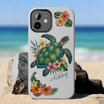 iPhone 12 case with a white background and a sea turtle with hibiscus flowers, with more hibiscus flowers around the sides.