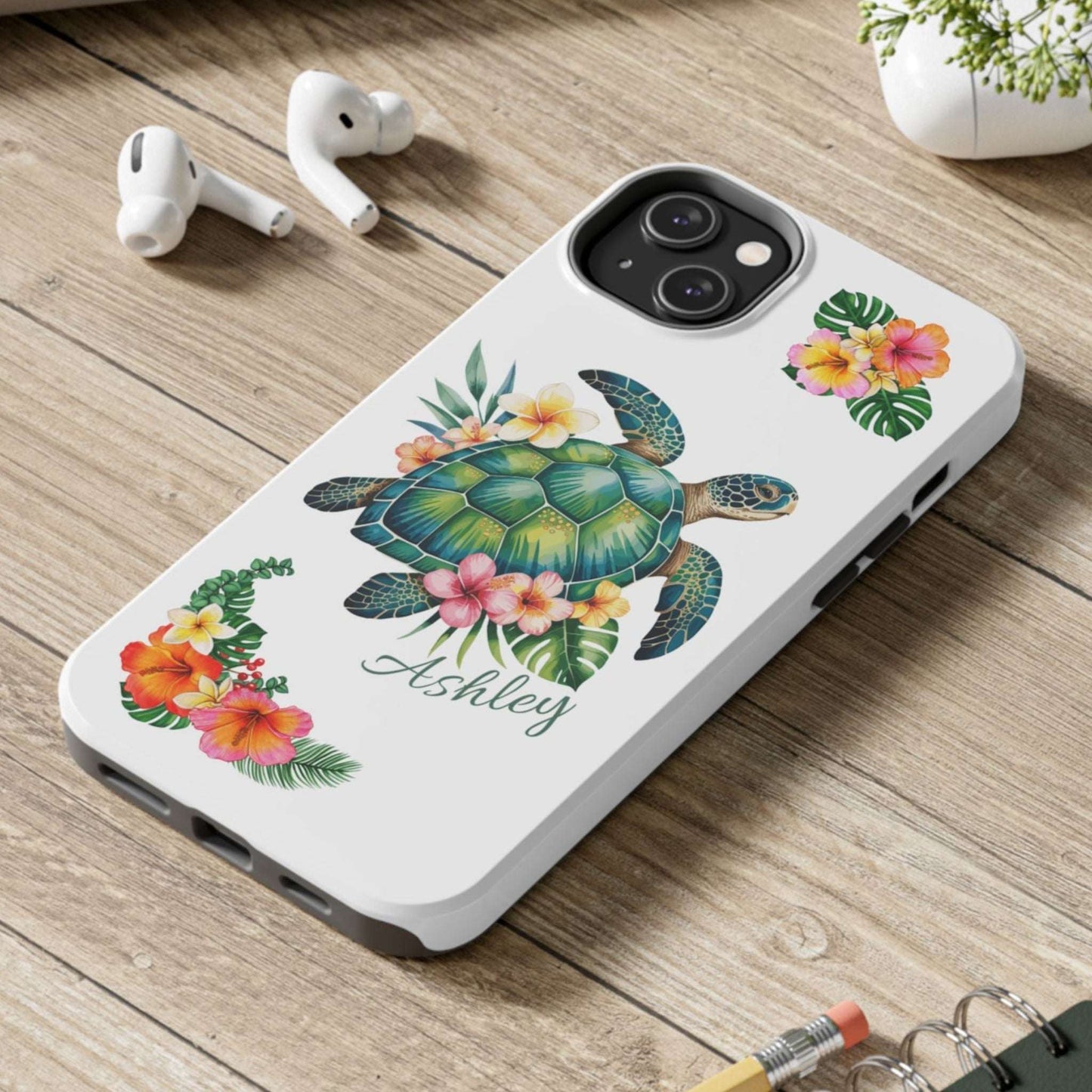 iPhone 14 case with a white background and a sea turtle with hibiscus flowers, with more hibiscus flowers around the sides.