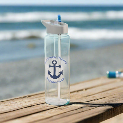 Clear water bottle with a blue anchor and the words Anchored Hearts and Dream High surrounding the anchor.