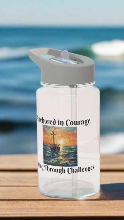 Clear Water Bottle with gray lid and straw with a picture of an old ship that says Anchored in Courage and Sailing through Challenges around it