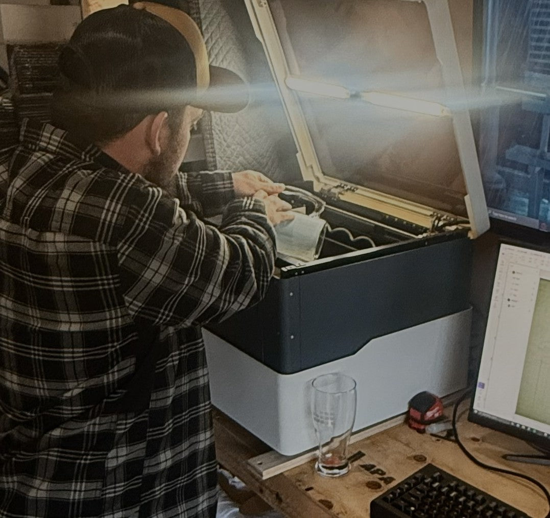 Person working on a computer and engraving setup displaying our process.