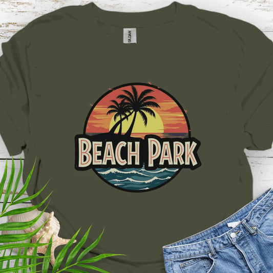 Military Green T-shirt with a vintage-style logo inspired by Jurassic Park, but with a beach theme featuring a circular emblem with a bold, retro font spelling 'BEACH PARK' in the center. The dinosaur silhouette is replaced with a tropical scene of palm trees.