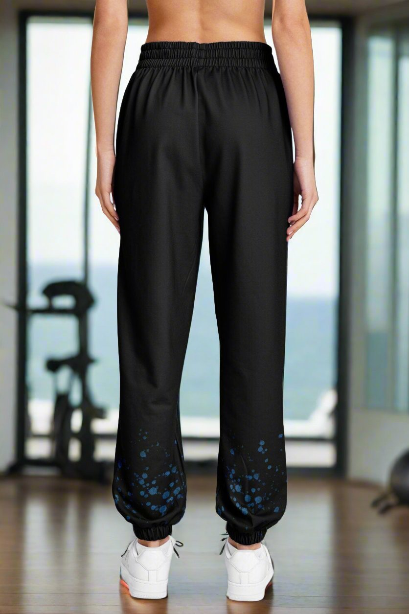 Back of black sweatpants with aqua bubbles coming up the bottom.