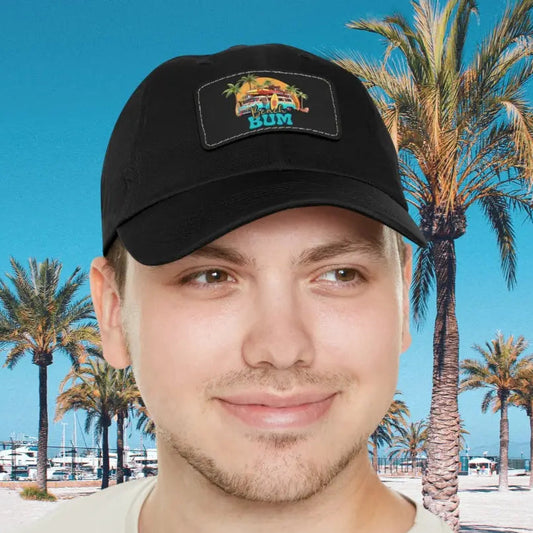 Man in black hat with leather patch that says beach bum with a beach van, surfboards, palm trees and sun.