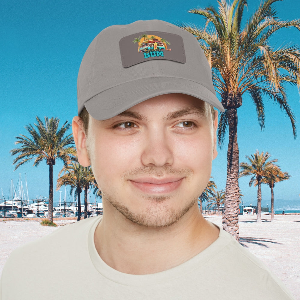 Man in gray hat with leather patch that says beach bum with a beach van, surfboards, palm trees and sun.