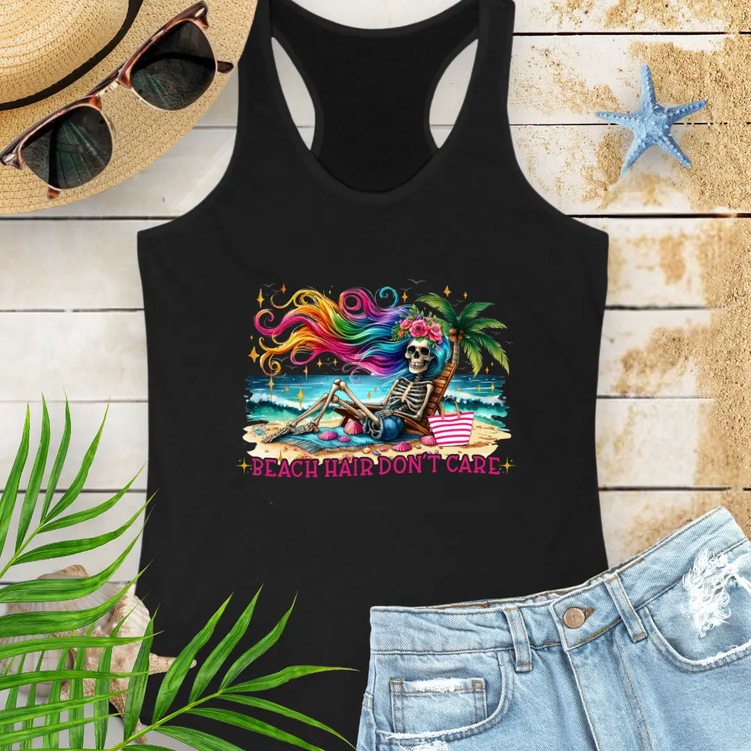 Black  Racerback Tank Top with a skeleton with rainbow hair flowing in the wind laying on a beach chair at the ocean that says Beach Hair Don't Care.