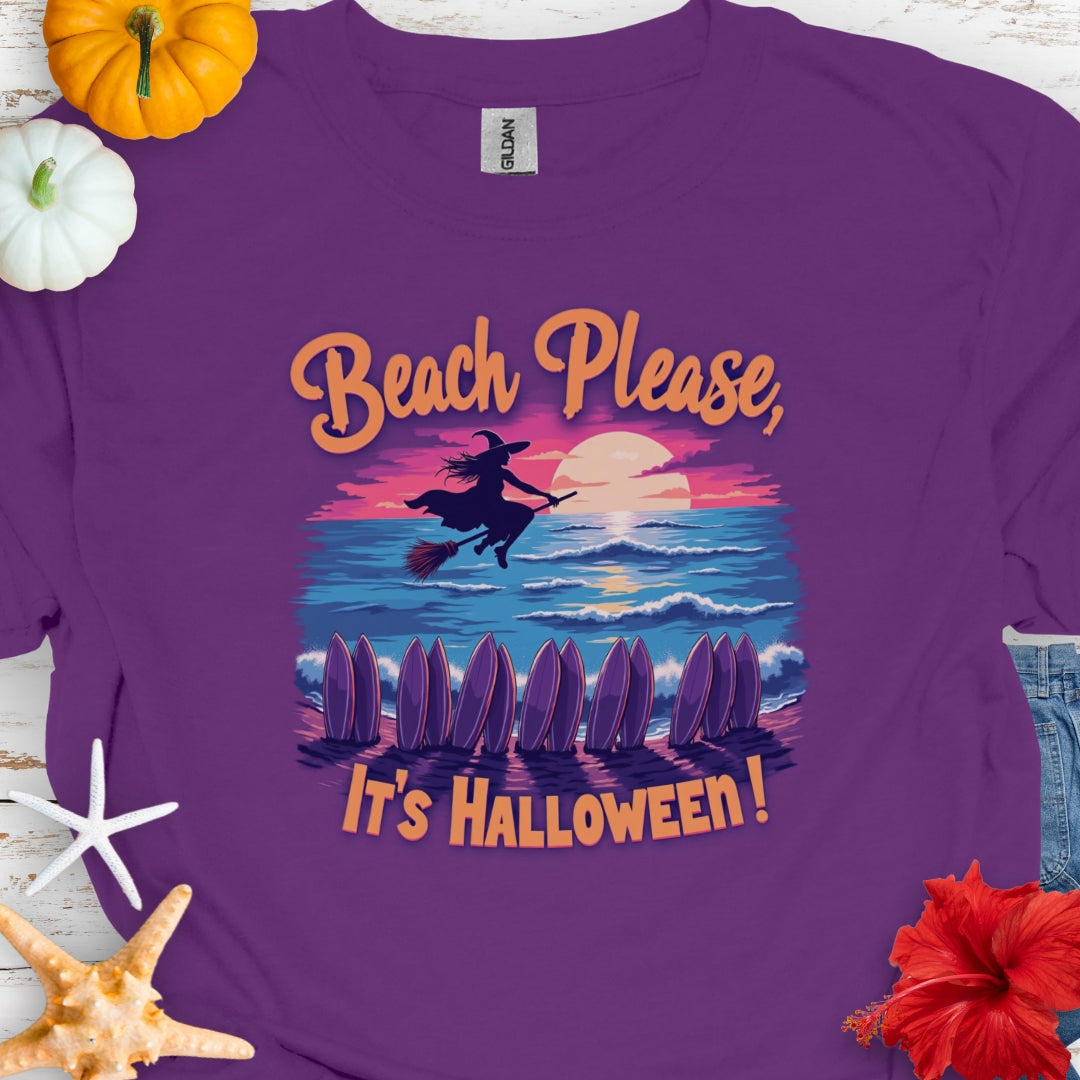 Purple t-shirt with  image of witch flying on a broom over the ocean with surfboards in the sand and text that says Beach Please, It's Halloween.