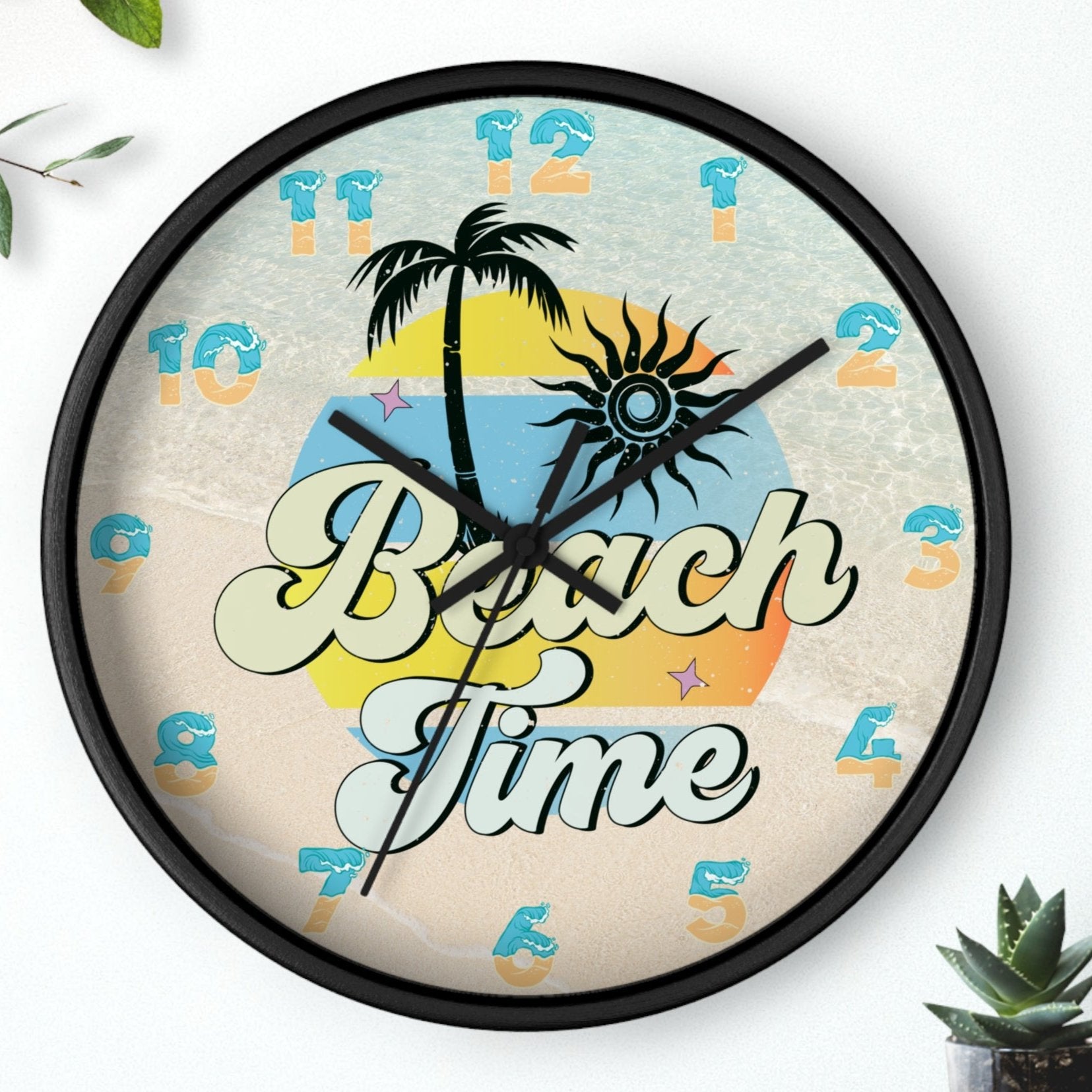 A circle wall clock with a black frame with black handles with an image of palm trees and sunset with a background of ocean water and sand that says Beach Time.