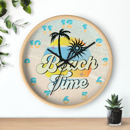 A circle wall clock with a wood frame with black handles with an image of palm trees and sunset with a background of ocean water and sand that says Beach Time.