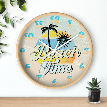 A circle wall clock with wood frame and white handles with an image of palm trees and sunset with a background of ocean water and sand that says Beach Time.