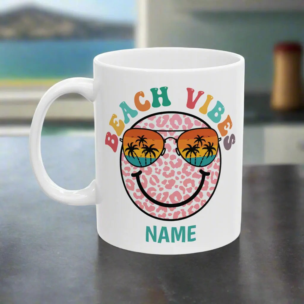 White 11 oz ceramic mug with "Beach Vibes" colorful text, featuring a retro smiley face wearing sunset sunglasses with palm trees. Personalized with a name, this coastal-themed coffee mug is perfect for beach lovers and summer vibes.text.