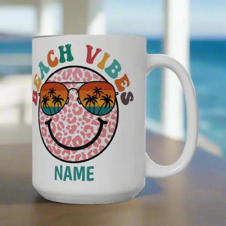 White 15 oz ceramic mug with "Beach Vibes" colorful text, featuring a retro smiley face wearing sunset sunglasses with palm trees. Personalized with a name, this coastal-themed coffee mug is perfect for beach lovers and summer vibes.