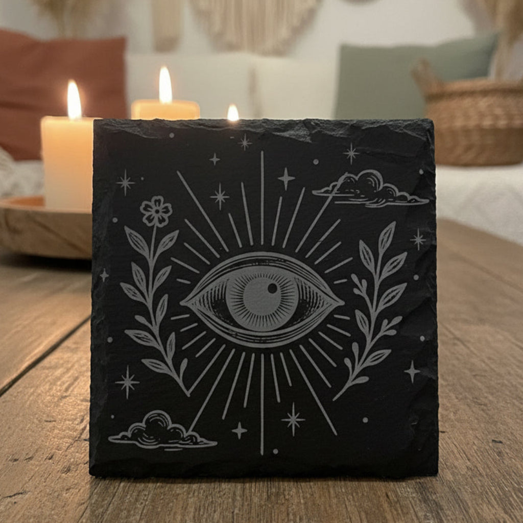 Decorative slate coaster with boho celestial eye design and floral elements.