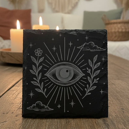 Decorative slate coaster with boho celestial eye design and floral elements.