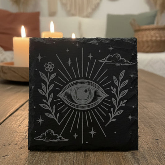 Decorative slate coaster with boho celestial eye design and floral elements.