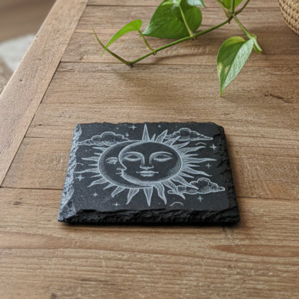 Slate coaster with sun and moon design on a woven basket background