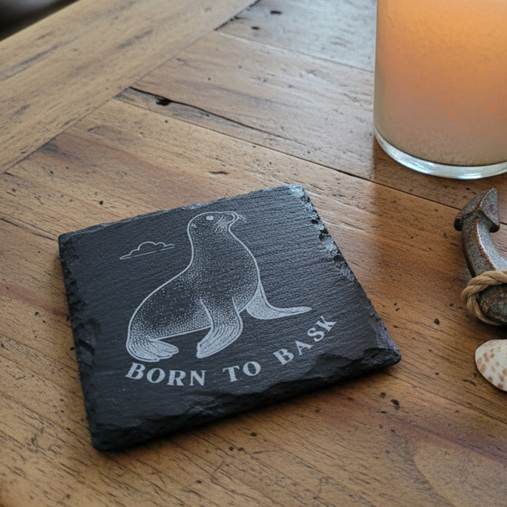 Slate coaster with seal design and 'Born to Bask' text engraved.