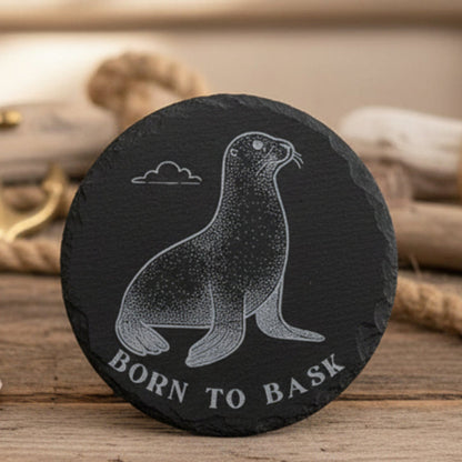 Black engraved 4" circle slate coaster with a seal illustration and 'Born to Bask' text.