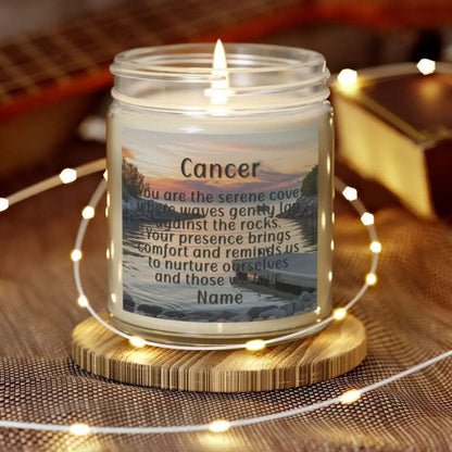 Elegant Cancer Zodiac hand-poured coconut apricot wax scented candle in a 9 oz clear glass jar, featuring a serene water and boat dock scene at sunset and an inspirational quote personalized. A beach-inspired astrology gift, perfect for relaxation and decor.