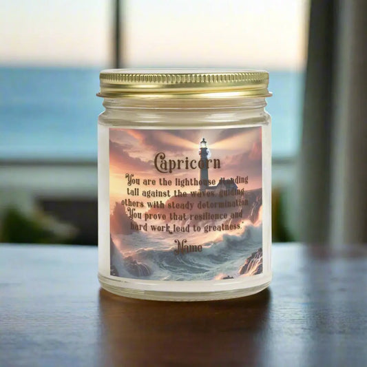 Elegant Capricorn Zodiac hand-poured coconut apricot wax scented candle in a 9 oz clear glass jar with gold lid, featuring a picture of crashing waves onto a lighthouse with an inspirational quote personalized. A beach-inspired astrology gift, perfect for relaxation and decor.