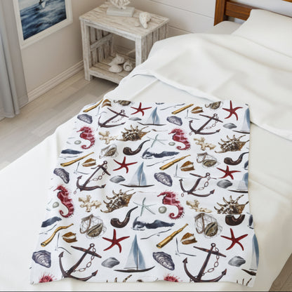 Nautical-themed blanket on a bed with a wooden nightstand in the background