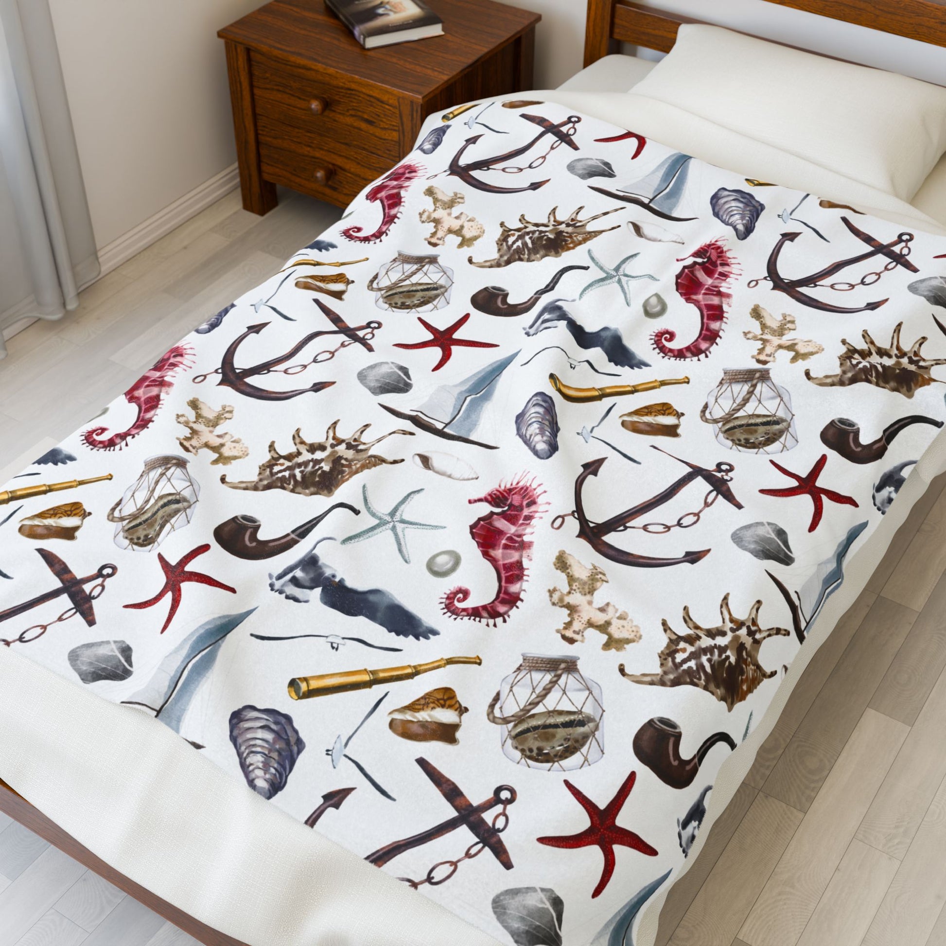 White blanket with nautical-themed design featuring anchors, stars, and shells on a white background.