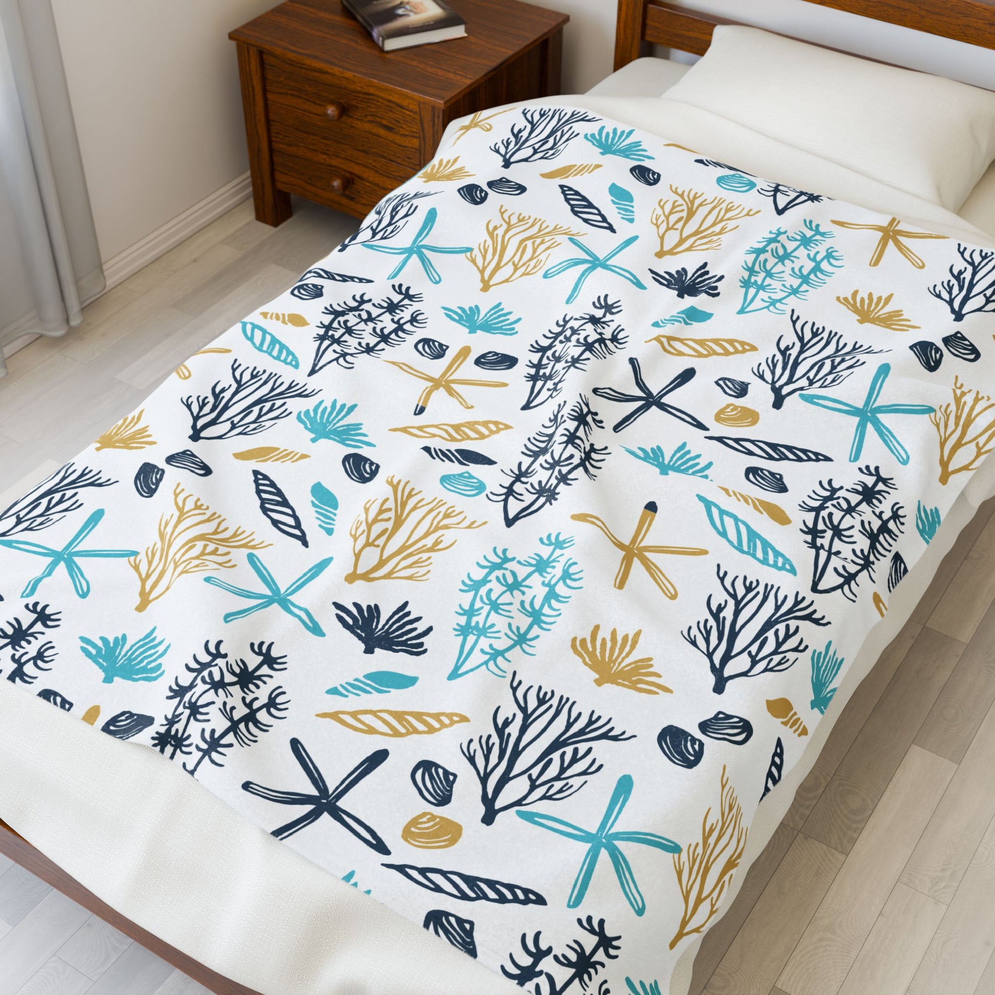 Bed with a colorful coral and starfish patterned comforter in a bedroom setting.