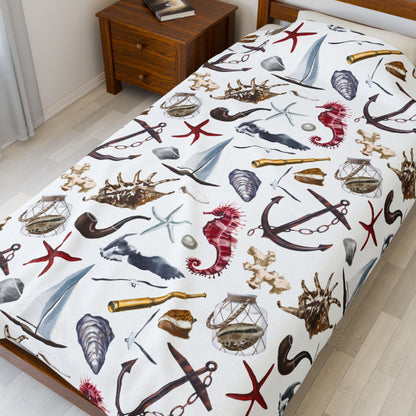 Bedspread with nautical-themed design featuring anchors, stars, and seahorses on a bed in a room.