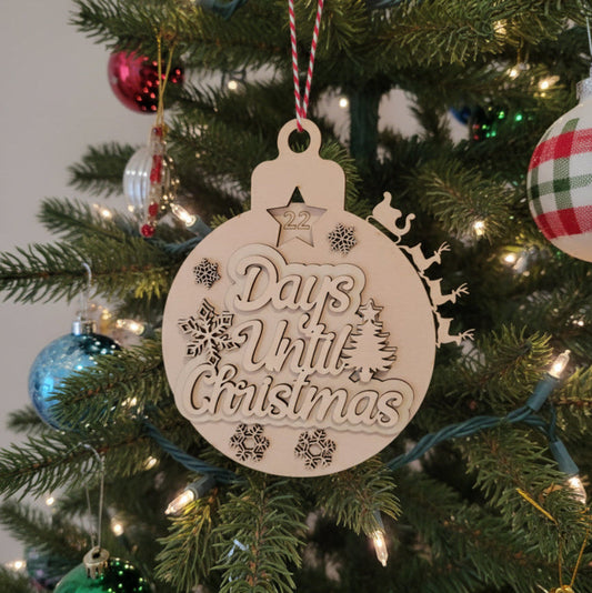 Decorative ornament counting 'Days Until Christmas' on a Christmas tree.