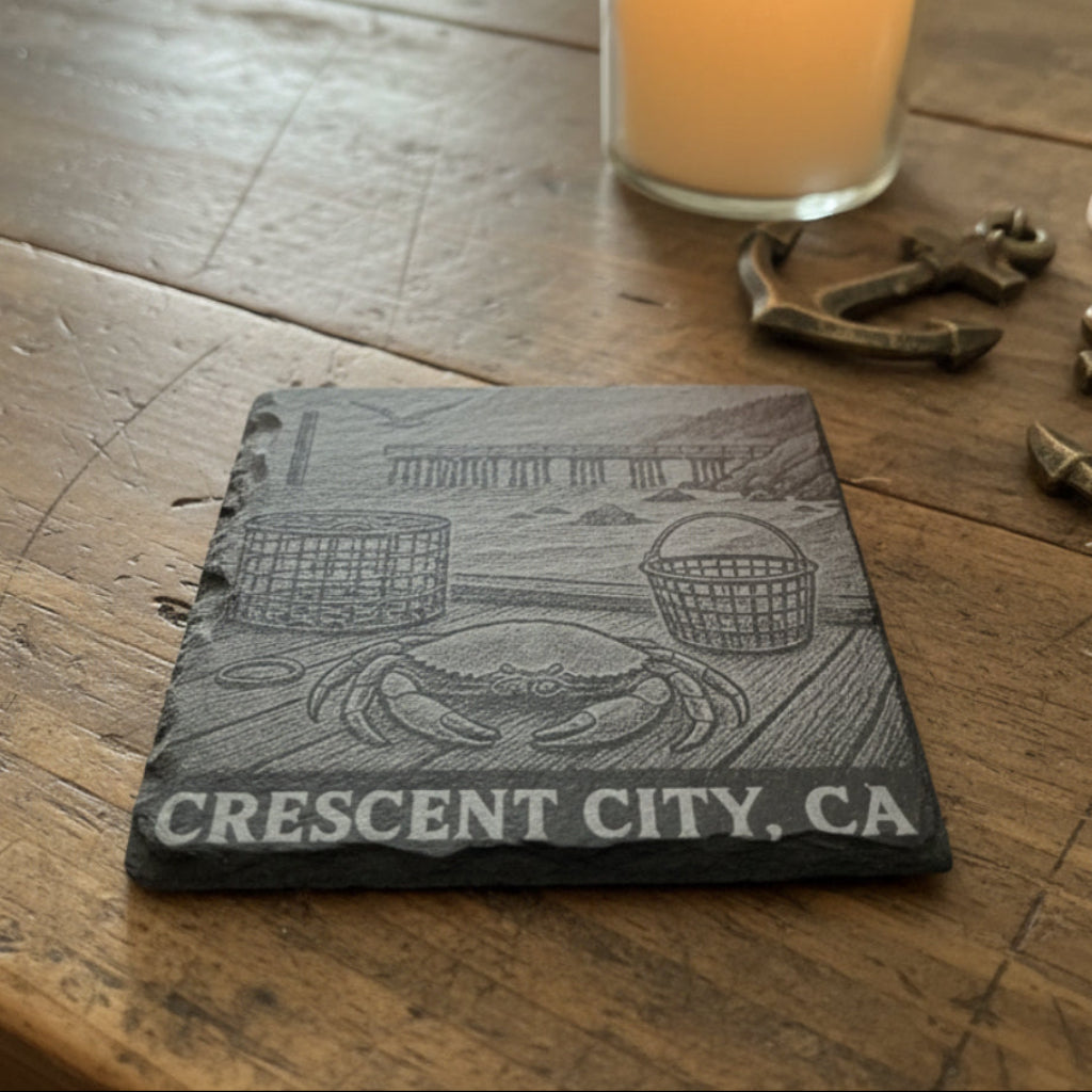 Black 4" slate coaster with a crab on a dock with the pier in the background with the text Crescent City, CA.