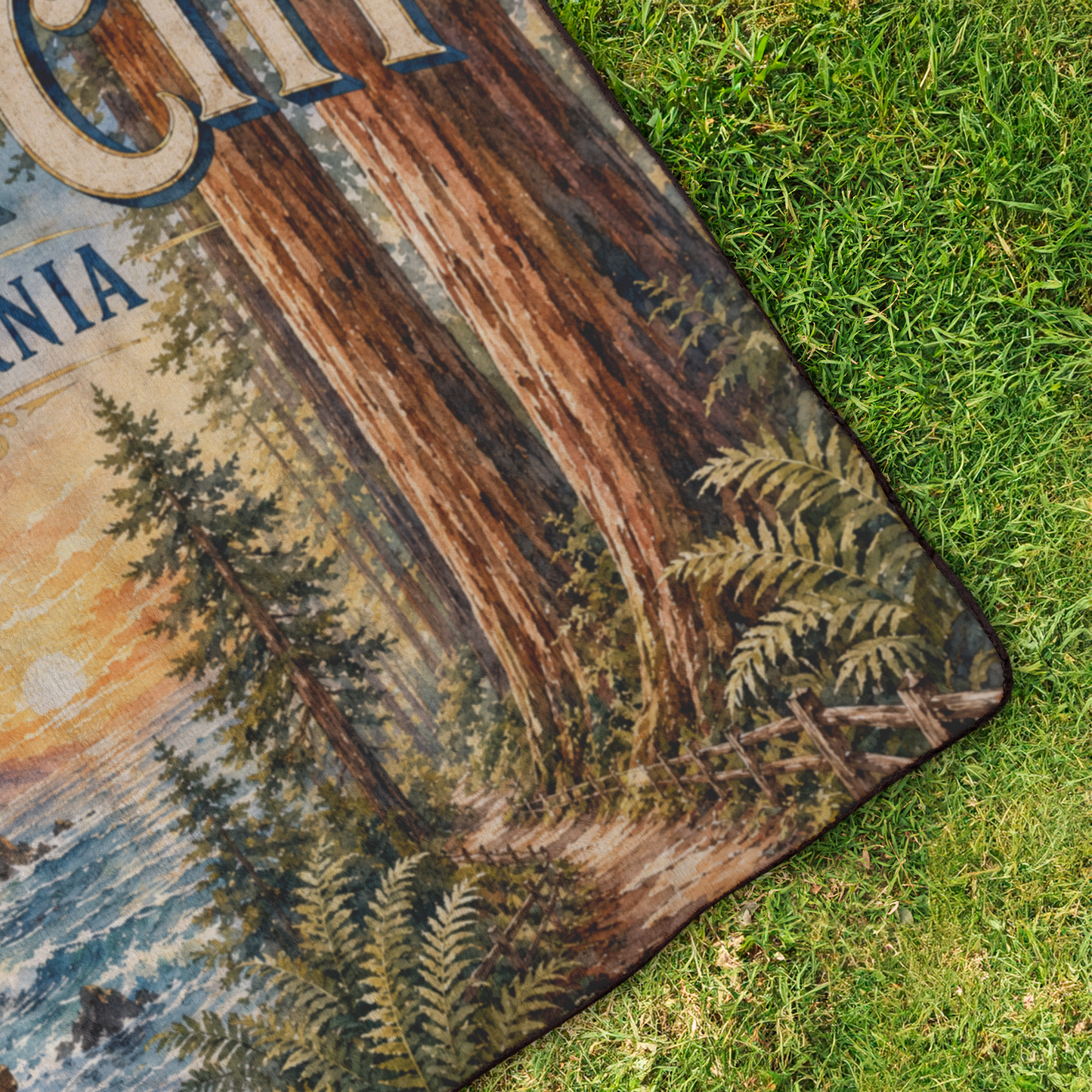 Corner of Crescent City California outdoor blanket featuring redwood trees, ocean cliffs, and a lighthouse with a plush fleece top and water-resistant backing.