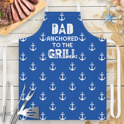 Blue apron with anchor patterns and text 'DAD Anchored to the GRILL.