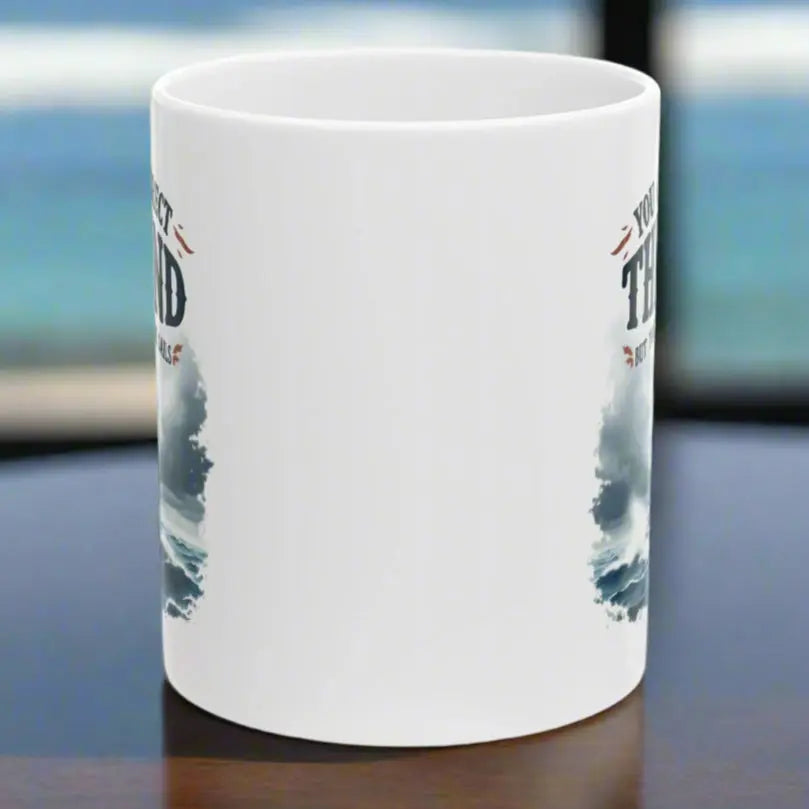 Side View of a white 11 oz. mug with a sailboat on the ocean with text 'You Can't Direct the Wind But You Can Adjust the Sails' with personalized name.
