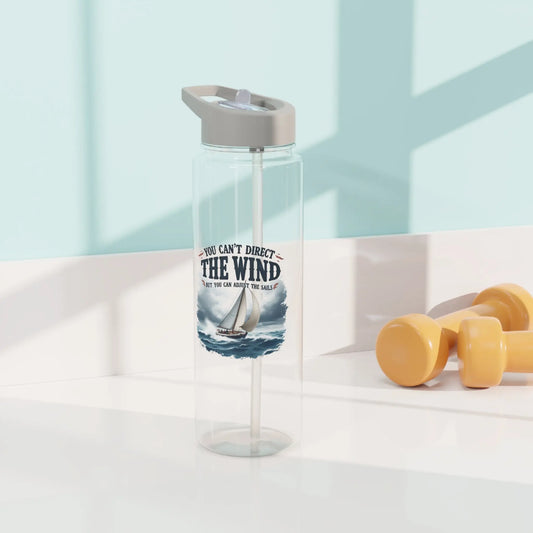 A clear 25 oz water bottle with a sailboat on the ocean with text 'You Can't Direct the Wind But You Can Adjust the Sails' with personalized name.