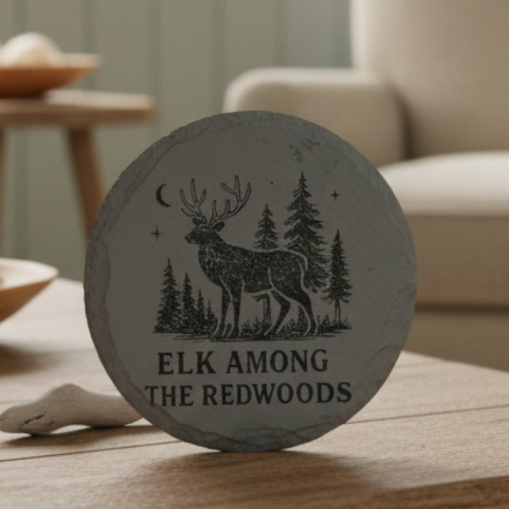 Decorative slate coaster with elk and forest design with text Elk Among the Redwoods.