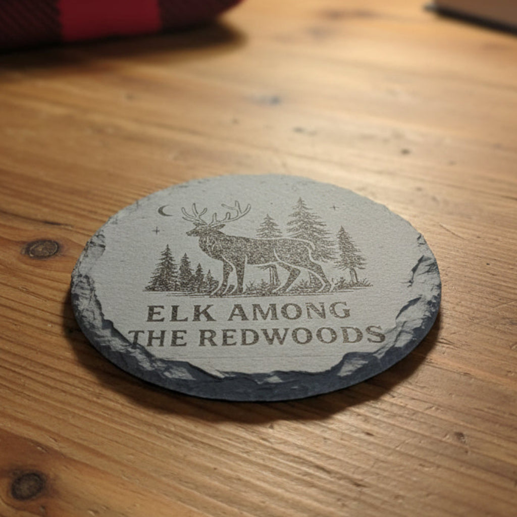 Round coaster with elk design and text Elk Among the Redwoods.