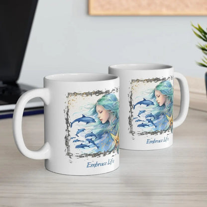 Two White 11 oz Ceramic Mug with a mermaid and swimming dolphins gives a mystical and positive vibe with the text Embrace Life - ideal for those who love the beach and marine life!