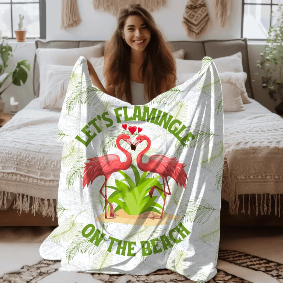 White velveteen plush blanket with green palm fronds and two flamingos in a heart shape that says Let's Flamingle. -perfect for snuggling on cold nights or as a comforting gift for a loved one who is a beach lover.