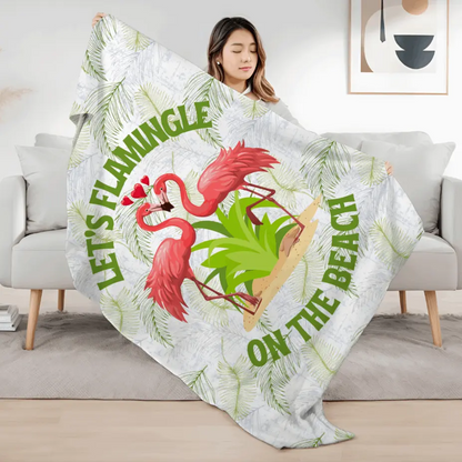White velveteen plush blanket with green palm fronds and two flamingos in a heart shape that says Let's Flamingle. -perfect for snuggling on cold nights or as a comforting gift for a loved one who is a beach lover.