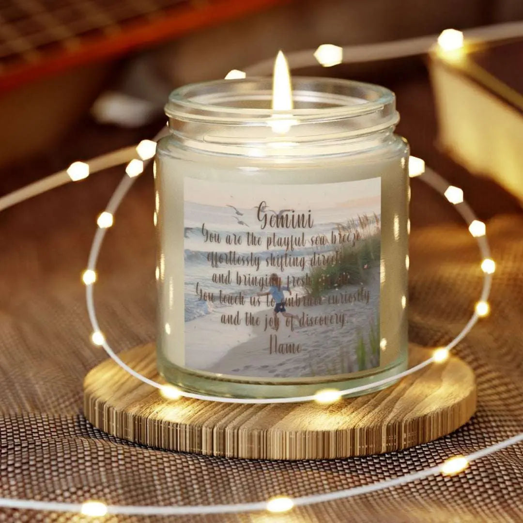 Elegant Gemini Zodiac hand-poured coconut apricot wax scented candle in a 4 oz clear glass jar, featuring a scene of crashing waves with a man in the distance on a rock with the bright sun shining off of the waves girl running  on the beach to the ocean water and an inspirational quote personalized. A beach-inspired astrology gift, perfect for relaxation and decor.