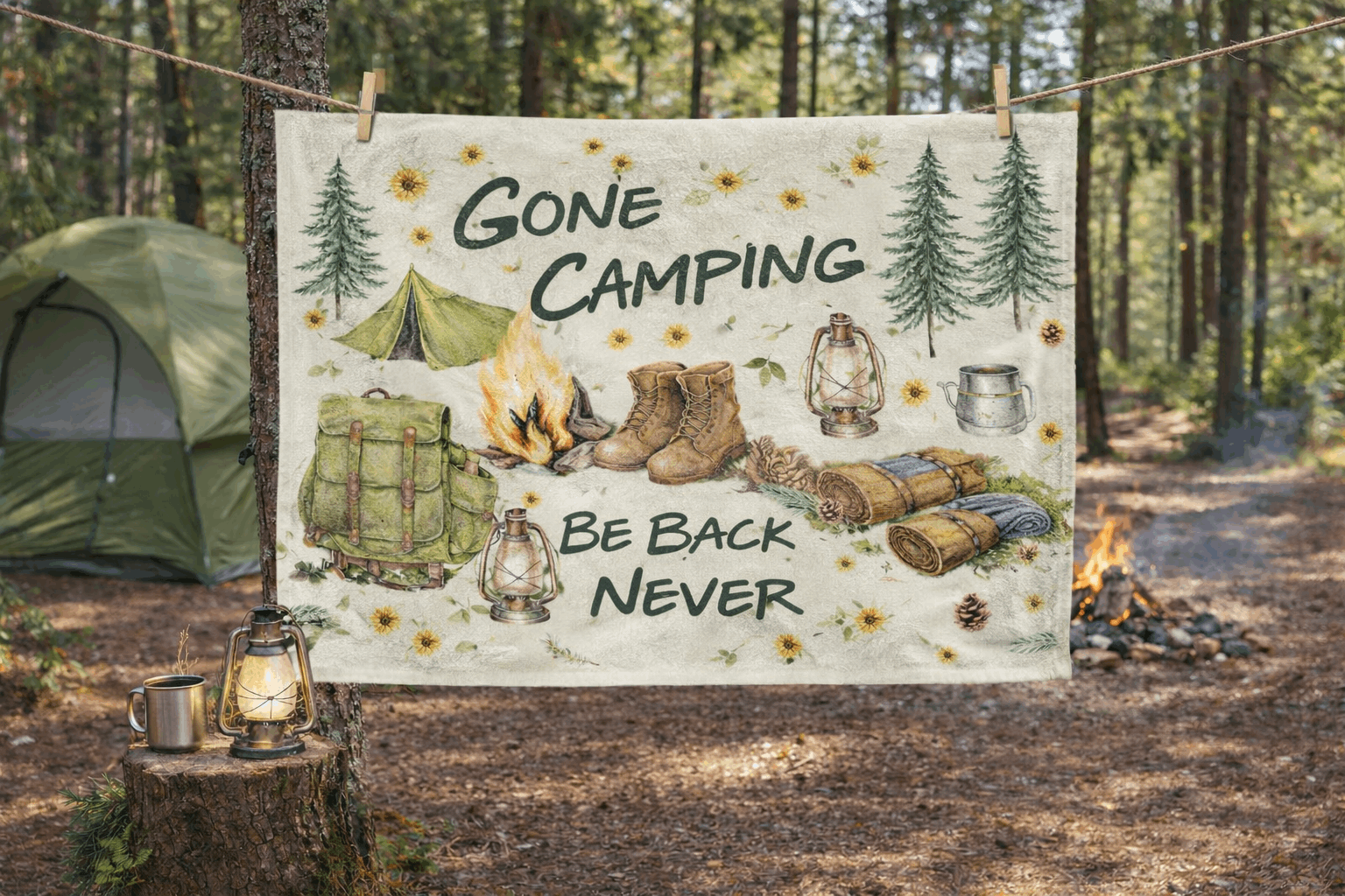 Camping-themed towel with text and illustrations hanging outdoors in a forest.
