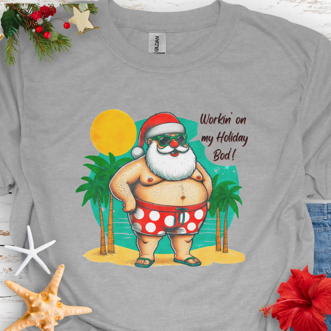 Gray T-shirt with Santa with swim shorts on the beach with text Workin' on my Holiday Bod'!