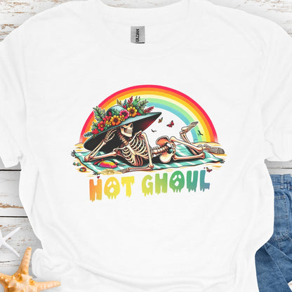 White  t-shirt with a girl skeleton laying on beach towel with flowered hat and rainbow with rainbow dripping text that says Hot Ghoul.