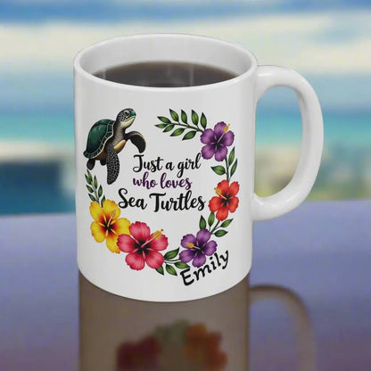 A white ceramic mug 11 0z. with a wreath of hibiscus flowers and a swimming sea turtle with text Just a girl who loves Sea Turtles and can be personalized with name.