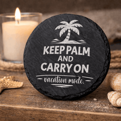 Round black slate coaster engraved “Keep Palm and Carry On vacation mode” with palm tree icon.