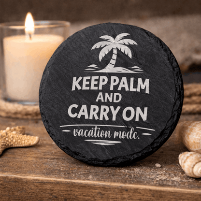 Round black slate coaster engraved “Keep Palm and Carry On vacation mode” with palm tree icon.