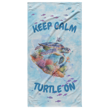 Light blue tie-dye beach towel with sea turtle and phrase “Stay Calm Turtle On”.