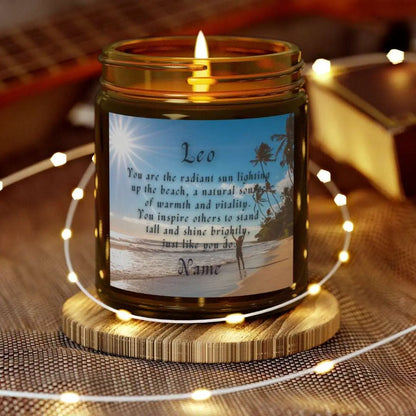 Elegant Leo Zodiac hand-poured coconut apricot wax scented candle in a 9 oz amber glass jar, featuring a picture of the ocean and beach with palm trees and woman raising her hands to the sun with an inspirational quote personalized. A beach-inspired astrology gift, perfect for relaxation and decor.